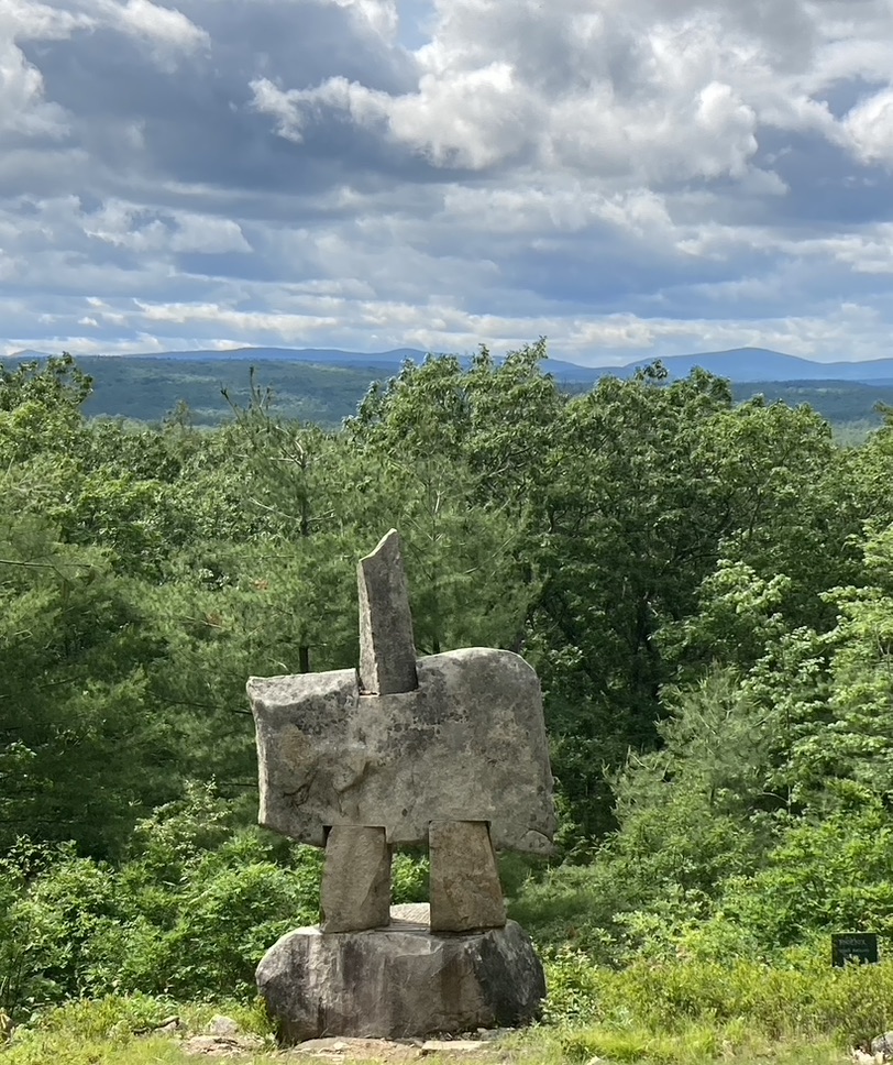 Outdoor sculpture titled "Phoenix" on a New Hampshire hill with a ridge of hills in the distance.